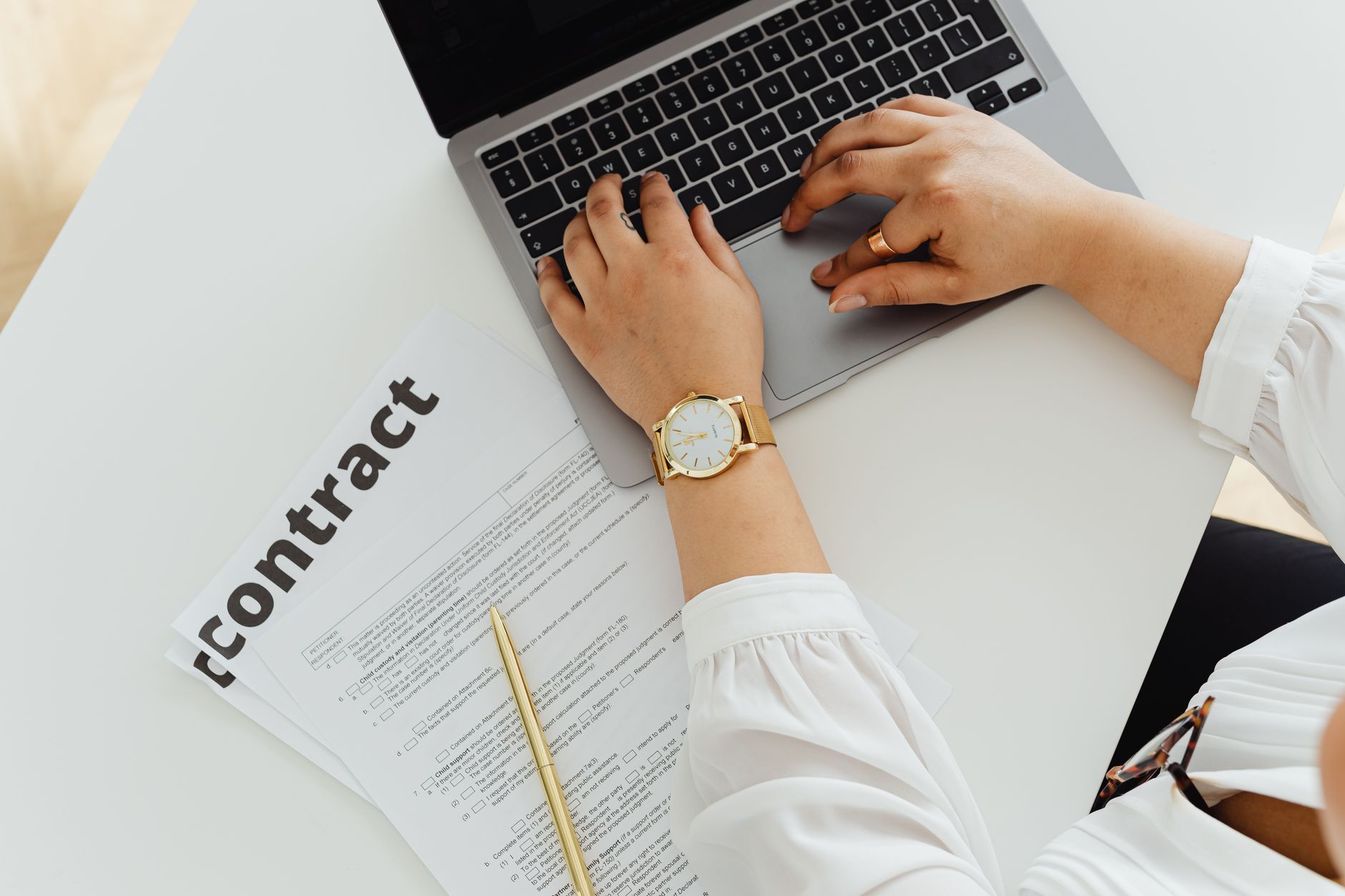 Professional using laptop with contract